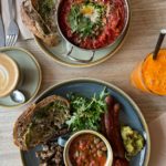 two brunch dishes with a coffee and a juice