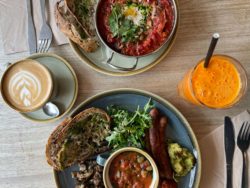 two brunch dishes with a coffee and a juice